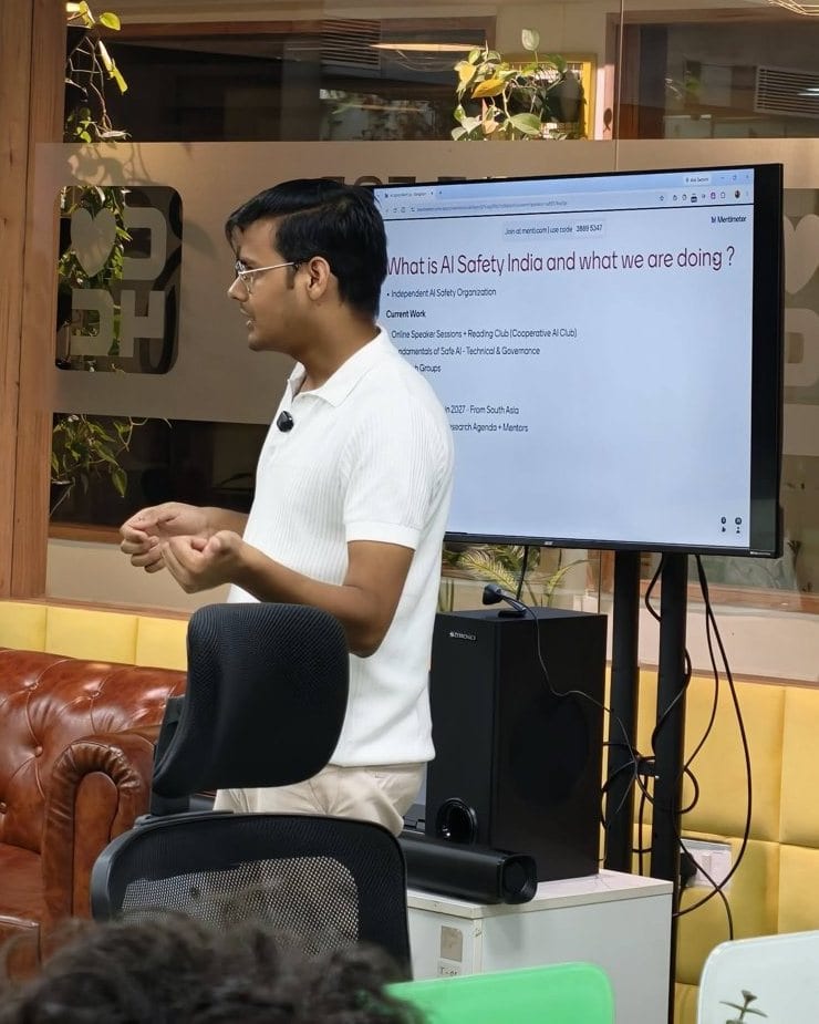 A speaker presenting at an AI Safety India event in Bengaluru.