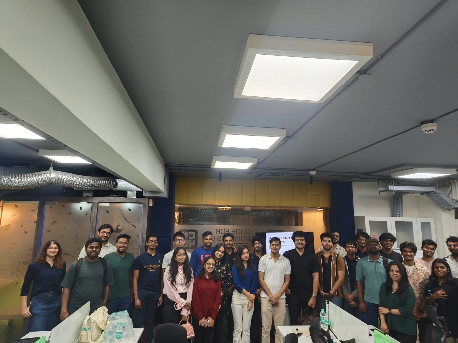 A large group stands together in a Bengaluru office after an AI Safety India meetup.